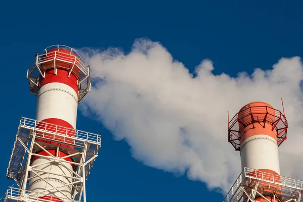 真っ青な空に白と赤の2つの工場煙突 — ストック写真