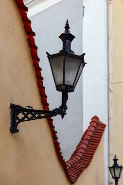 Çitlere asılmış antik sokak lambası.