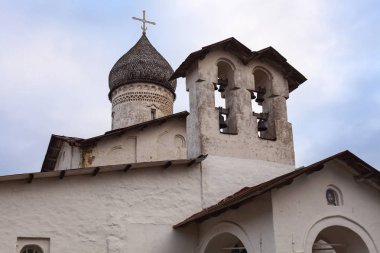 Ancient orthodox temple with a dome covered with wooden tiles against a dramatic sky