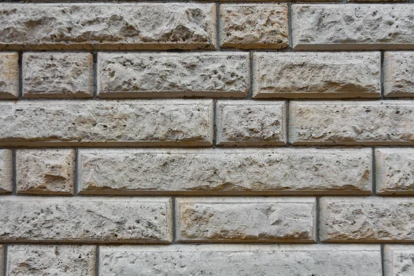 The background image is a wall of embossed bricks of different sizes in gray