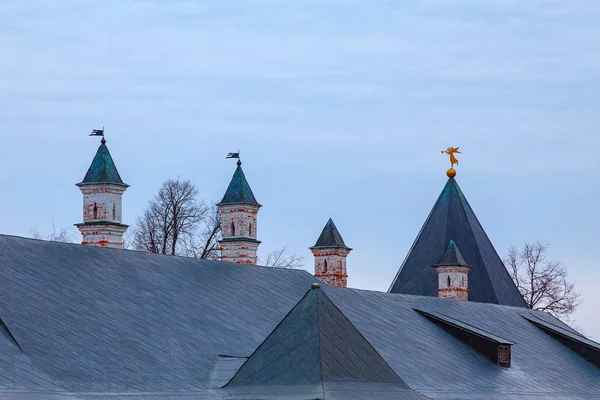 修道院屋顶上有不同高度的带有金属旗的炮塔 — 图库照片