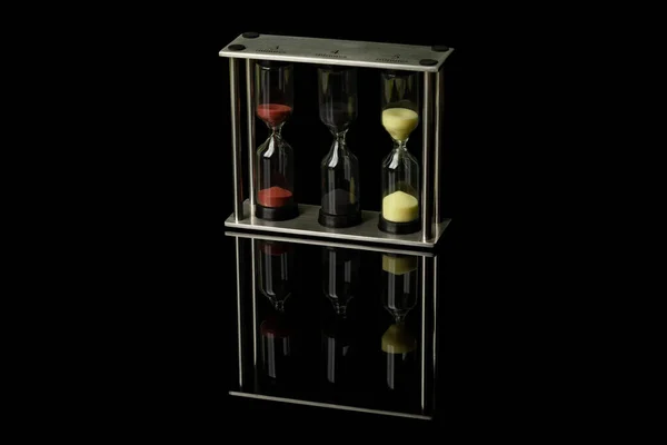 Renkli Kumlu Saat Bardağı Siyah Parlak Bir Camda Duruyor Yansımaları — Stok fotoğraf