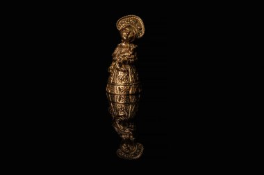Geleneksel Rus elbisesi içinde bronz bir kız figürü ve kokoshnik parlak siyah bir camda yansıması görünür.