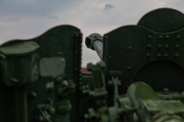 Eski bir topçu tüfeğinin bagajı yağmurlu gökyüzüne doğru yönelir.