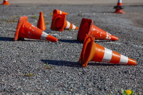 Old plastic cones scattered along the road