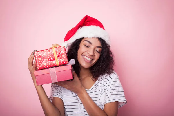Mujer afroamericana en sombrero de santa celebrando la Navidad con cajas de regalo —  Fotos de Stock