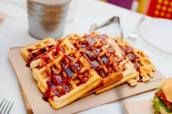 Viennese waffles poured with berry topping. Viennese wafers with berry jam. Delicious and healthy breakfast.