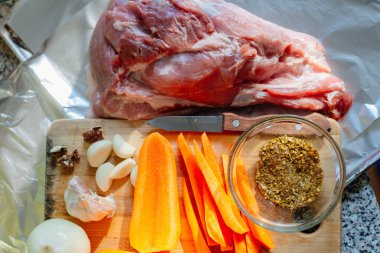 Haşlanmış domuz pişirme işlemi. Taze et pişmeye hazır, yanında havuç, sarımsak ve baharatlar var..