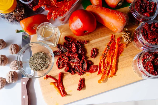 Sun-dried tomatoes and dried carrots with olive oil and Provencal herbs. The process of making dried tomatoes. Ingredients for Vegetable Chips top view