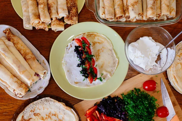 Farklı dolgulu ev yapımı krepler. Yumuşak peynir, domates ve fesleğenle doldurulmuş krep..