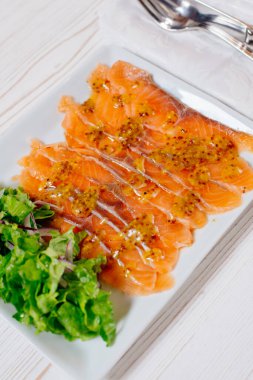 Hardal soslu, marul ve soğan turşulu füme somon dilimleri. Üst görünüm beyaz arkaplan