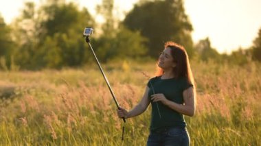 Neşeli genç kadının selfie seyahat yapması. Sıcak tonları. Gün batımında.