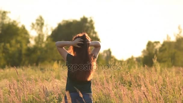 Fantastic young woman outdoors. A young woman raises his arms for joy. In warm tones. — Stock Video
