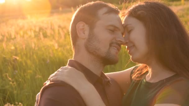 Los amantes se tocan la nariz mientras caminan en el parque al atardecer . — Vídeos de Stock