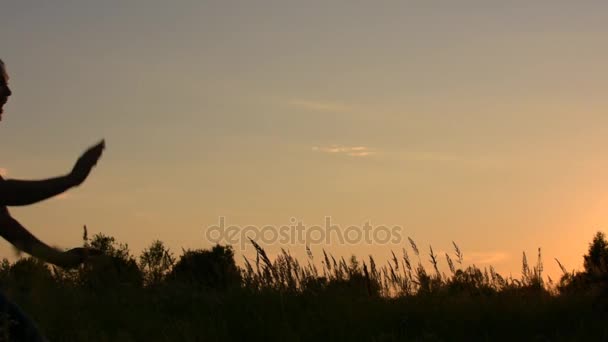 Lovers appear in the frame. running toward each other. The young man takes his girlfriend on . On the background of the sunset sky. — Stock Video