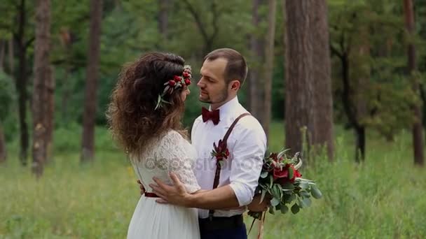 Young couple groom and bride in the woods. A big bunch of twigs and flowers. Smile. — Stock Video