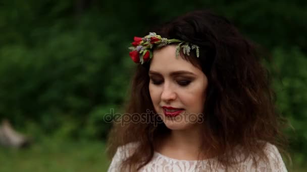 Красивая невеста корона из свежих цветов на голове на открытом воздухе в летнем лесу. Крупный план — стоковое видео