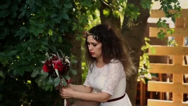 Красивая невеста в винтажном платье с цветным букетом свежих цветов. Смотреть в камеру и улыбаться . — стоковое видео