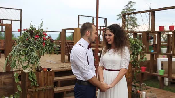 Wedding in rustic style. Lovers standing at the altar, holding hands.Smile. Worried — Stock Video