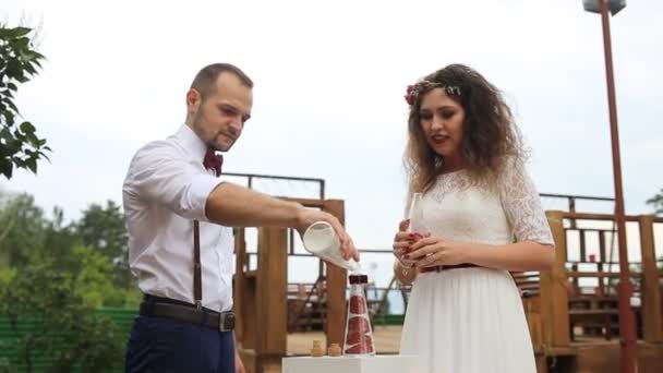 Pareja riendo en el fondo de las decoraciones de la boda. La mezcla de arena — Vídeos de Stock