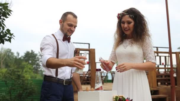 O belo casal, por sua vez, derramou areia na garrafa. Cheio de felicidade. A mistura de areia — Vídeo de Stock