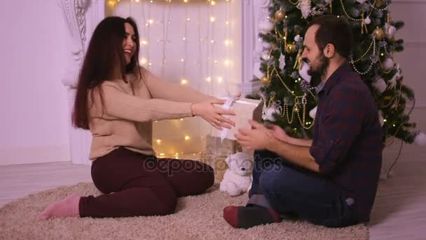 Bela jovem mulher dá seu namorado um bom presente no Natal . — Vídeo de Stock