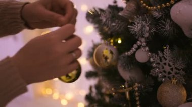 Narin ve güzel eller genç kadının ağaç Noel oyuncaklar dekorasyon.