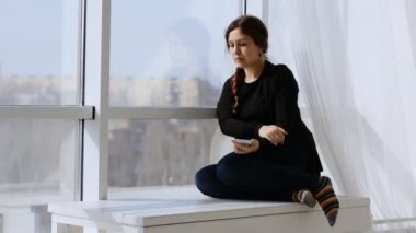 Genç ve güzel bir kadın telefonda neşeli bir mesaj alıyor ve gülüyor..