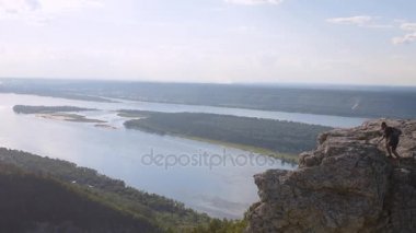 Adam dağın zirvesine tırmandı ve zafer belirtisi içinde elleri kaldırdı