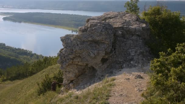 Sommar vandring. En turist klättrar till toppen. — Stockvideo