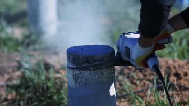 Человек режет бетонную колонну. Искры металлической и бетонной пыли — стоковое видео