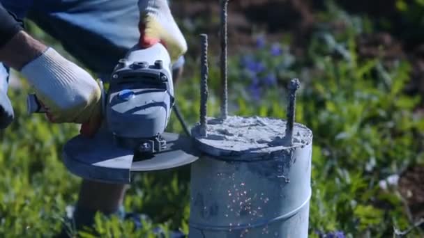 Un hombre cortando una columna de hormigón. Chispas de metal y polvo de hormigón. Construcción . — Vídeo de stock