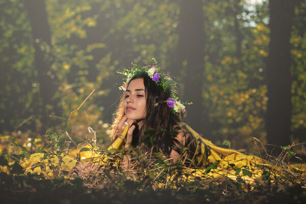 Young woman looking happy in forest in an autumn day