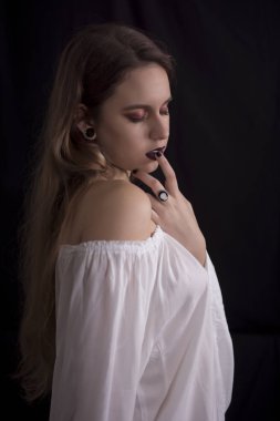 Beyaz elbise siyah arka plan üzerine poz olan kadın