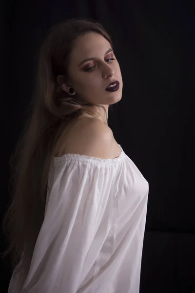 ポーズを黒の背景に白のドレスの若い女性 — ストック写真