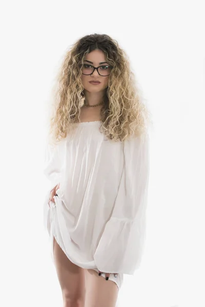 Kadın kıvırcık saçlı ve beyaz elbise beyaz arka plan üzerinde poz