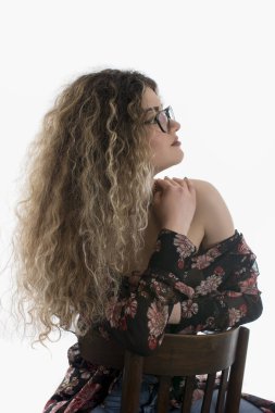 Kadın kıvırcık saçlı ve beyaz arka plan üzerinde poz çiçek elbise