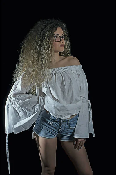 Kadın Kıvırcık Saçlı Kot Pantolon Beyaz Gömlek Siyah Arka Plan — Stok fotoğraf