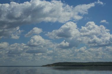 Dnipro Nehri'nin inanılmaz manzara. Güzel bir mavi gökyüzü beyaz bulutlar, yeşil pelerin ve ufukta bir yelkenli yat.