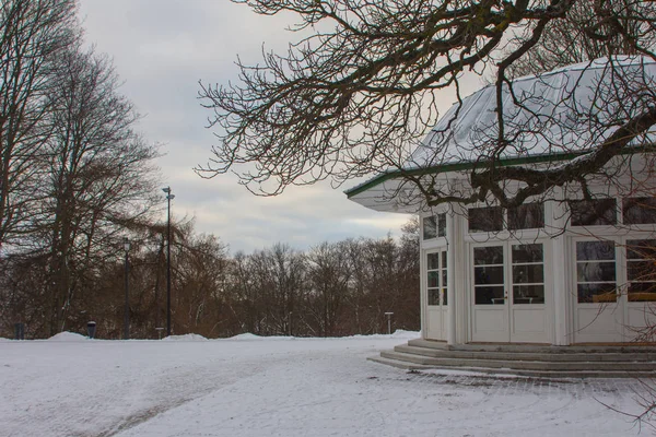 White wooden pavilion in the snow-covered park of Tallinn. Estonia