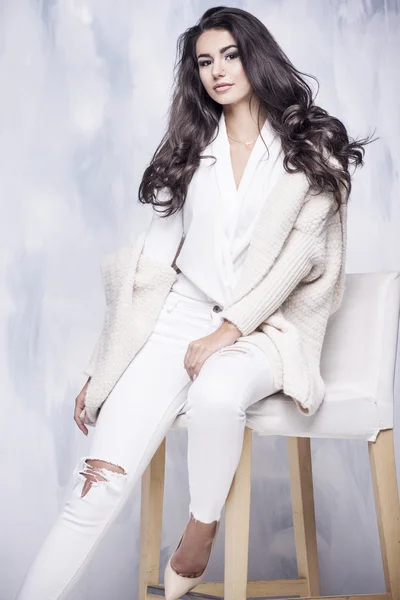 Mooie vrouw gekleed in witte kleren met een warme trui — Stockfoto