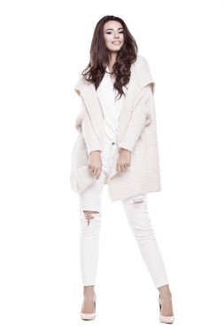 Sıcak kazak ayakta beyaz bir arka plan üzerinde giyen güzel kadın