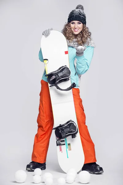 Jovem mulher bonita em roupas de inverno e snowboard — Fotografia de Stock