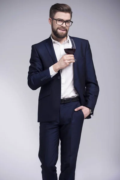 Bir bardak şarap tutan bir sakallı yakışıklı adam — Stok fotoğraf