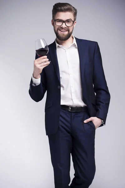 Bir bardak şarap tutan bir sakallı yakışıklı adam — Stok fotoğraf