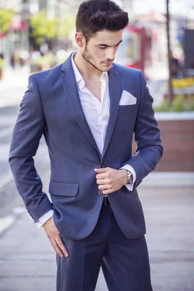Junger, gut aussehender Geschäftsmann, der elegant gekleidet durch die Stadt läuft — Stockfoto