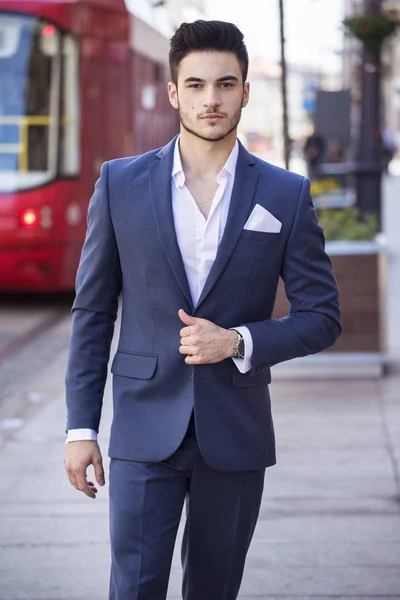 Joven hombre de negocios guapo vestido elegante, caminando por la ciudad — Foto de Stock