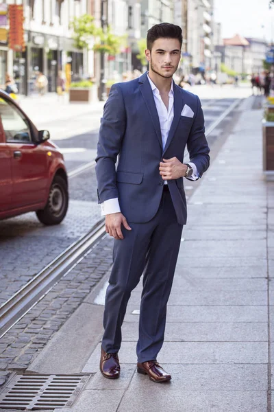Jovem empresário bonito vestido de forma inteligente, andando pela cidade — Fotografia de Stock