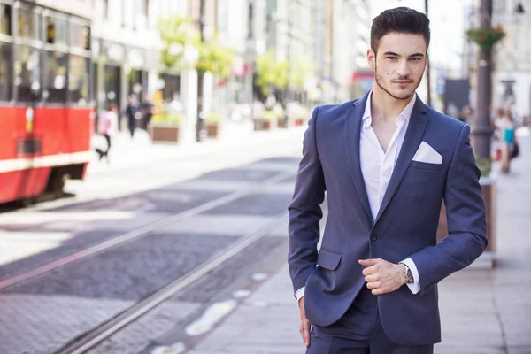 Junger, gut aussehender Geschäftsmann, der elegant gekleidet durch die Stadt läuft — Stockfoto