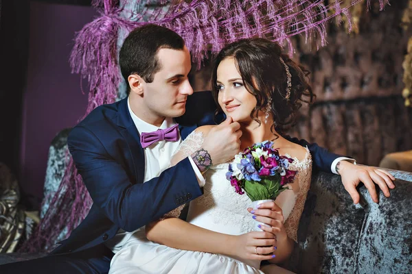 Hochzeitstag. Braut und Bräutigam in einem luxuriösen Interieur in Lavendelfarbe. Hochzeitsgefühle. schöne Braut und eleganter Bräutigam bei der Zeremonie. — Stockfoto